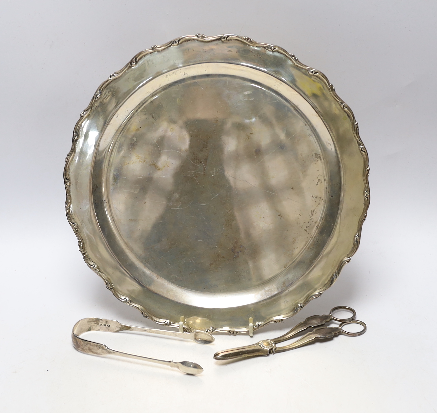 A 20th century Mexican 925 sterling circular platter, 30.1cm, a pair of Georgian silver sugar tongs and a later pair of silver grape shears, 26oz.